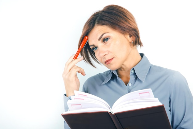 Dame d'affaires avec un stylo rouge et des documents dans ses mains sur un fond blanc