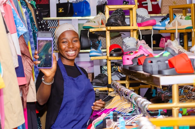 Photo dame africaine utilisant une carte de crédit et un point de vente dans une boutique