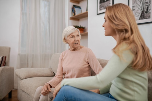 Dame âgée communiquant avec sa fille dans le salon