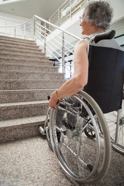 Une dame âgée en fauteuil roulant levant les yeux