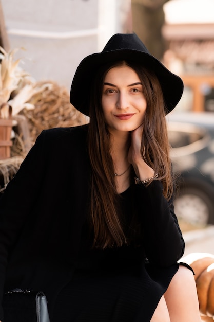 dame brune posant au café. Portrait de style de mode.