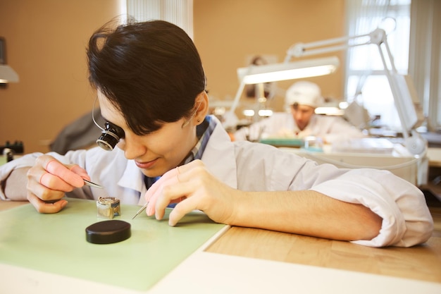 Dame concentrée travaillant avec de petits morceaux