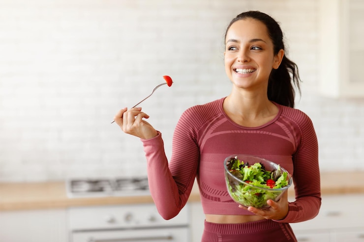 Photo une dame en forme savoure une salade saine dans la cuisine à la maison