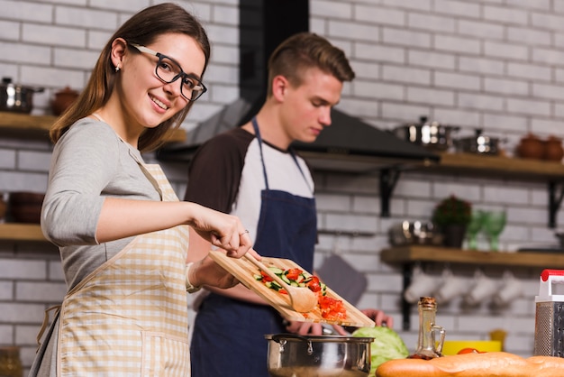 Dame gaie cuisine salade près de petit ami