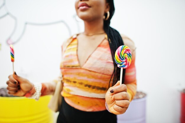 Dame millénaire afro-américaine au magasin de bonbons avec sucettes