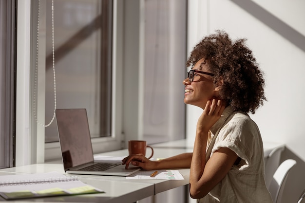 Dame Multiethnique Souriante Appréciant Son Travail Au Bureau