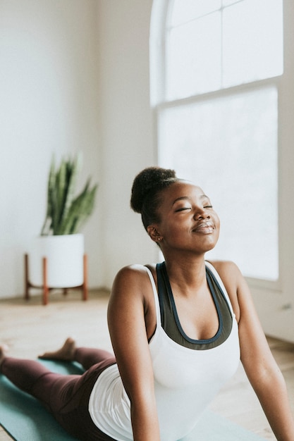 Dame noire faisant une pose Bhujangasana