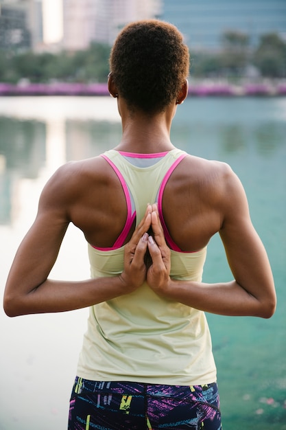 Dame noire faisant un yoga dans un parc