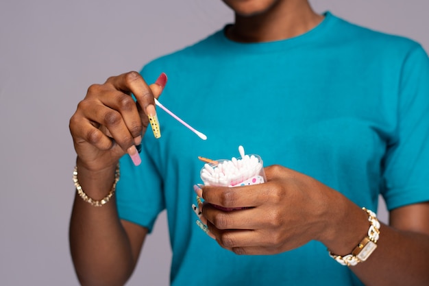 Dame noire prenant un coton-tige pour nettoyer son oreille