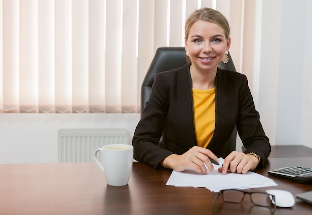 Dame patronne regardant directement la caméra alors qu'elle était assise dans son bureau