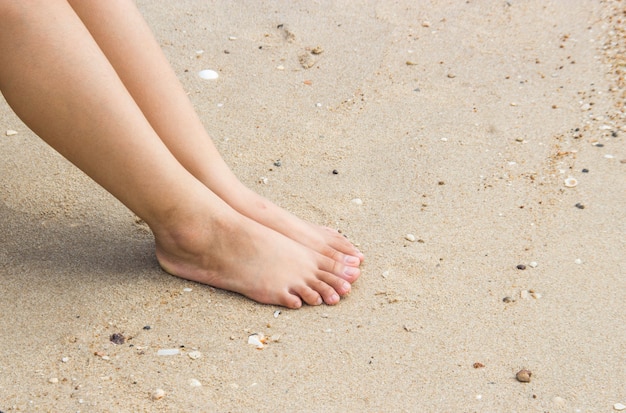 Dame pied et les jambes sur le sable