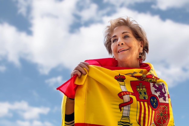 Dame plus âgée souriante entourée d'un drapeau de l'Espagne Fierté d'être Espagnol Amour patriotisme Colomb jour