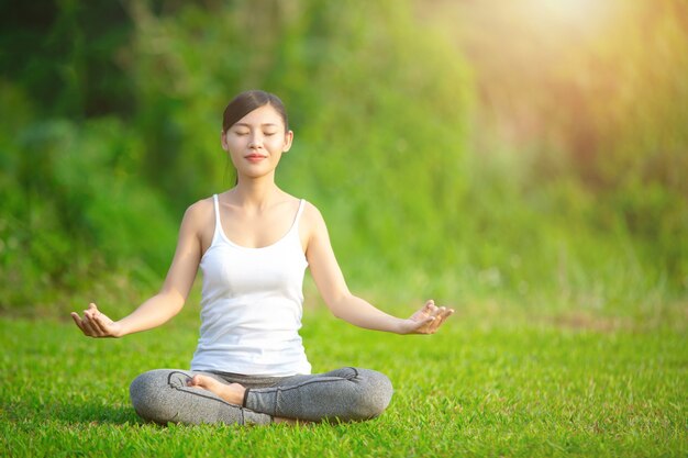 Dame pratiquant le yoga dans le parc en plein air, la méditation.