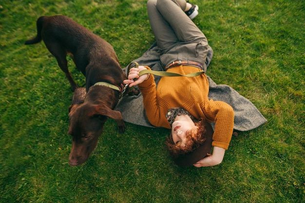 Dame se reposant sur une promenade avec un concept d'animaux de compagnie de chien