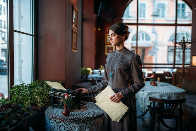 Dame sérieuse aux cheveux noirs se tient près de la table