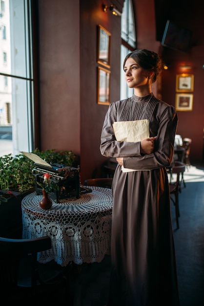 Dame sérieuse aux cheveux noirs se tient près de la table