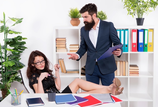 Dame sexy se détendre à table sur le lieu de travail. vie de bureau glamour. homme de chef de la direction en colère contre une fille coquine. relations commerciales. les partenaires commerciaux travaillent ensemble. vous ne pouvez pas gérer le travail. où est mon rapport.