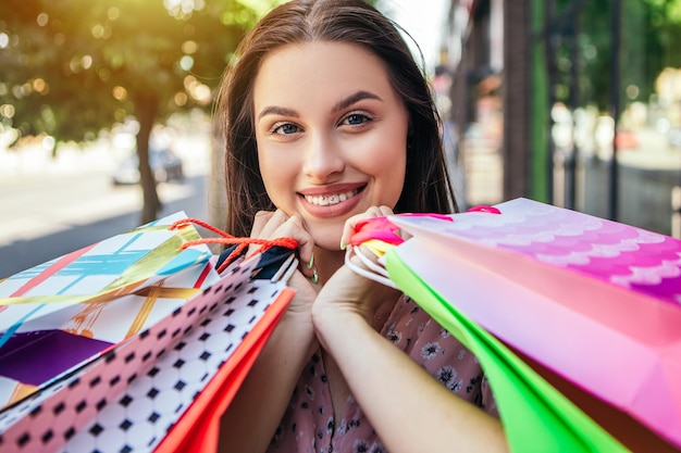 La dame tient beaucoup de sacs après le shopping