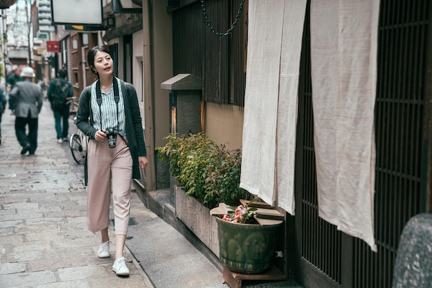 dame touriste visitant le japon marchant dans la rue traditionnelle de la ville. jeune voyageur appréciant le voyage d'osaka. Voyage au Japon fille de vacances d'été profitant de la ville.