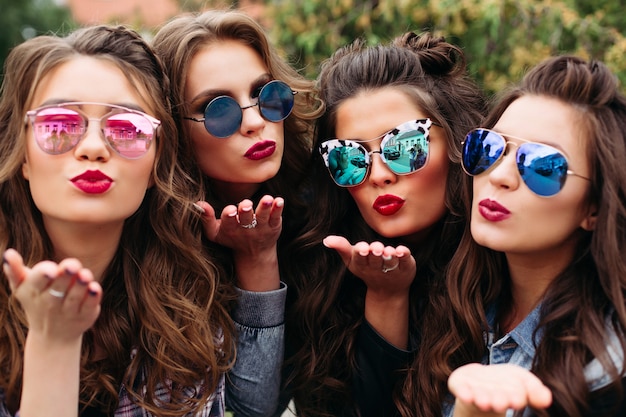 Dames à la mode avec coiffure prenant selfie à l'extérieur.