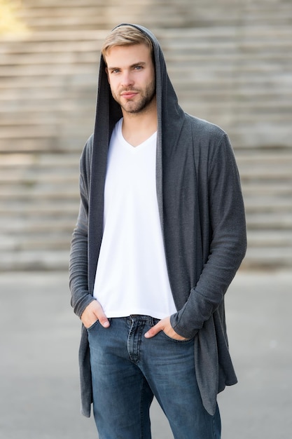 Dangereusement bel homme en capuche hooligan porter un sweat à capuche ressemblant à un voleur en cardigan à capuche Concept de style décontracté de danger et de confiance Mode urbaine look ville vie moderne homme en sweat à capuche