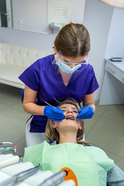 Dans une clinique dentaire spécialisée, une femme dentiste reçoit des clients avec des problèmes de dents