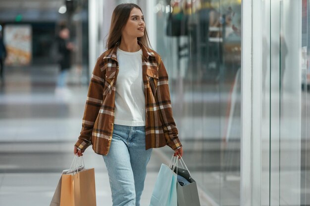 Dans le couloir, une femme fait ses courses au supermarché.