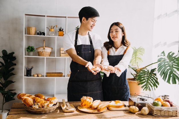 Dans la cuisine Un couple parfaitement heureux prépare des aliments sains Beaucoup de légumes L'homme jongle avec des fruits fait rire sa petite amie De belles personnes amoureuses s'amusent