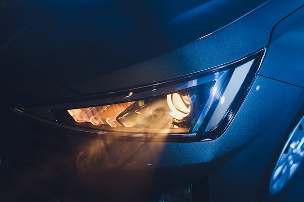 Photo dans le garage du salon de l'automobile, les phares centraux de la voiture sont très proches, allumer et éteindre en vérifiant les dimensions de l'éclairage avant