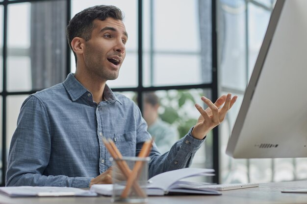 Dans un grand bureau d'entreprise diversifié, portrait d'un beau manager utilisant un ordinateur de bureau