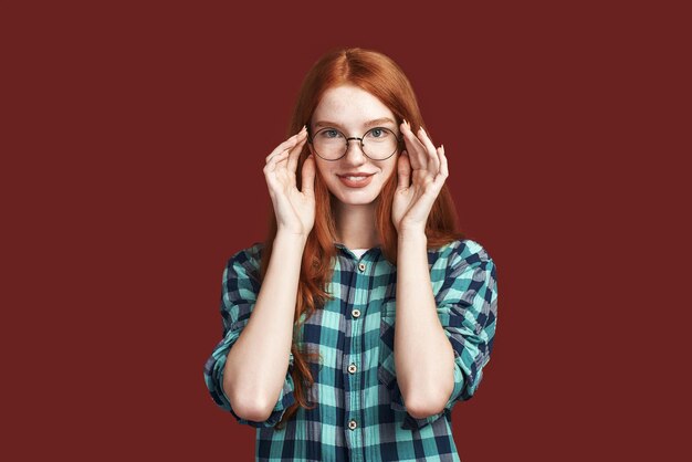 Dans une humeur enjouée rousse joyeuse touchant des lunettes