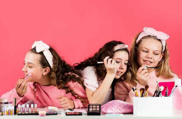 Photo dans leur propre style temps de liaison familiale bonheur de l'enfance enfants rétro se maquiller soins de la peau cosmétiques pour enfants beauté et mode trois filles heureuses chez le coiffeur amitié et fraternité