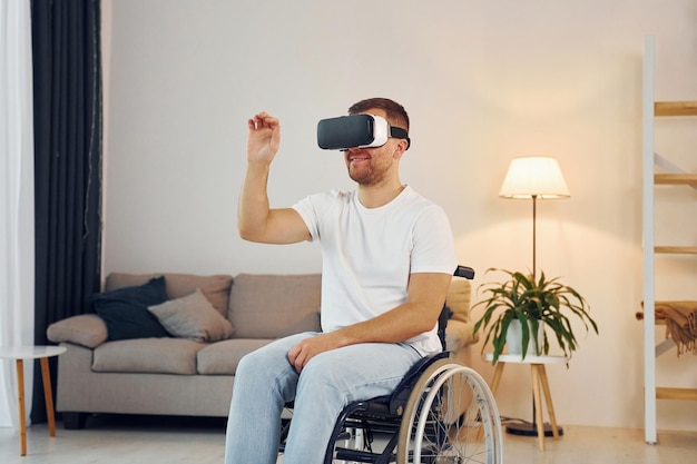 Dans les lunettes VR Un homme handicapé en fauteuil roulant est à la maison