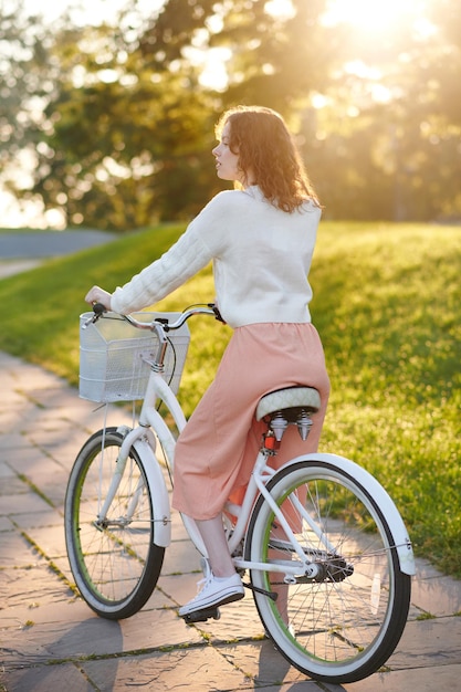 Dans le parc. Jeune fille avec un vélo dans le parc