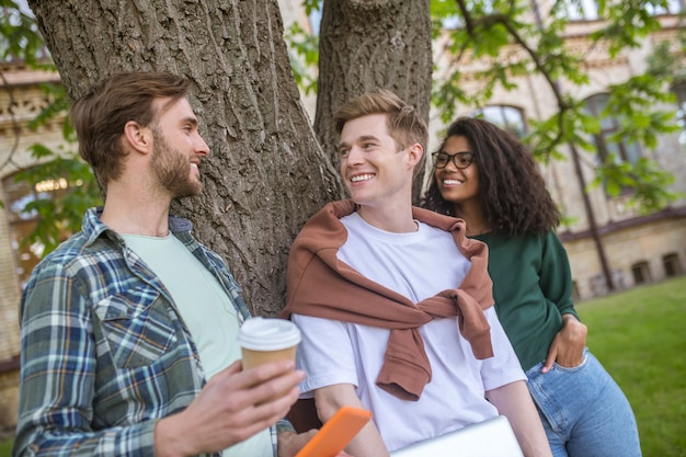 Dans le parc. Les jeunes debout près de l'arbre dans le parc