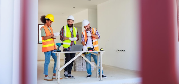 Dans les portes Équipe d'ingénieurs mécaniques professionnels portant un casque de sécurité travaillant dans une usine de fabrication en chantier