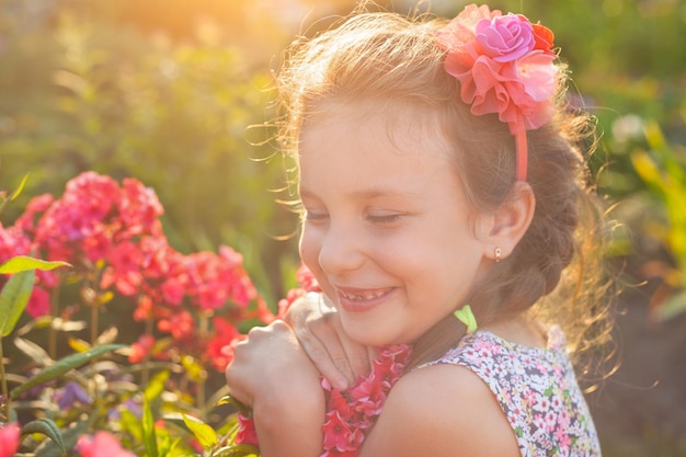 Dans les rayons du soleil couchant, la fille embrasse le phlox rouge