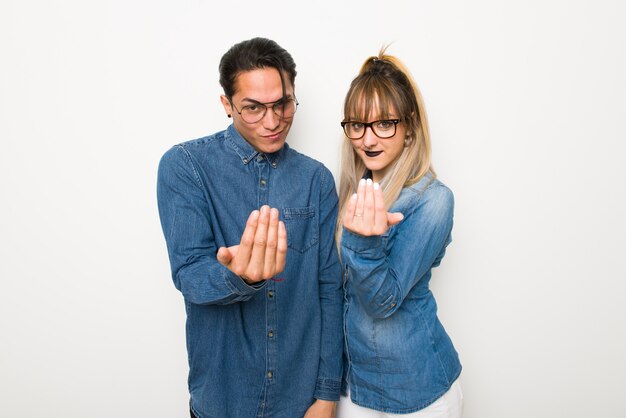 Dans la Saint Valentin Jeune couple avec des lunettes invitant à venir avec la main. Heureux que tu sois venu