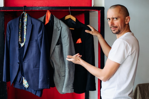 Dans une salle d'exposition de vêtements pour hommes, un gars choisit un costume pour une entrevue