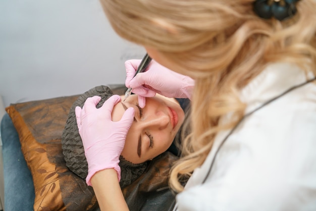 Dans le salon de beauté chez le tatoueur belle cliente heureuse.