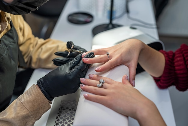 Dans un salon de beauté prestigieux, un merveilleux maître fabrique un nouveau vernis gel pour une cliente