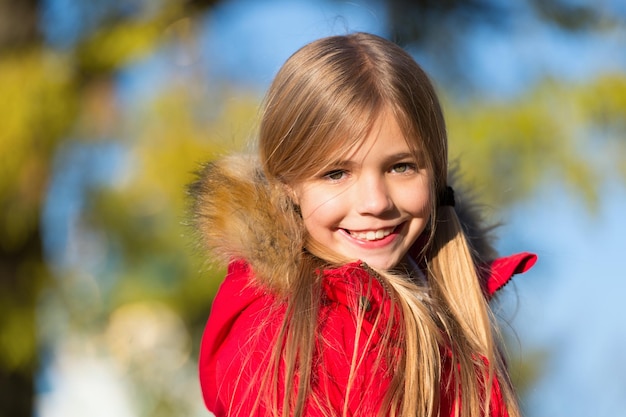 Dans son propre style Garder les vêtements chauds du corps les jours d'automne Concept de tenue d'automne Enfant joyeux lors de la promenade d'automne Manteau chaud meilleur choix pour l'automne Enfant fille porter un manteau pour la saison d'automne fond de nature