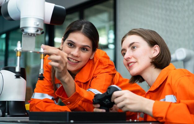 Dans une usine de pièces électroniques, deux ingénieures inspectent et testent des robots.