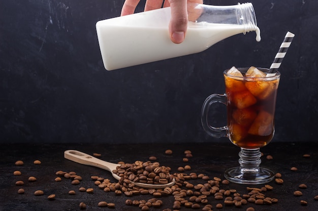 Dans un verre de café froid, versé du lait d'une bouteille