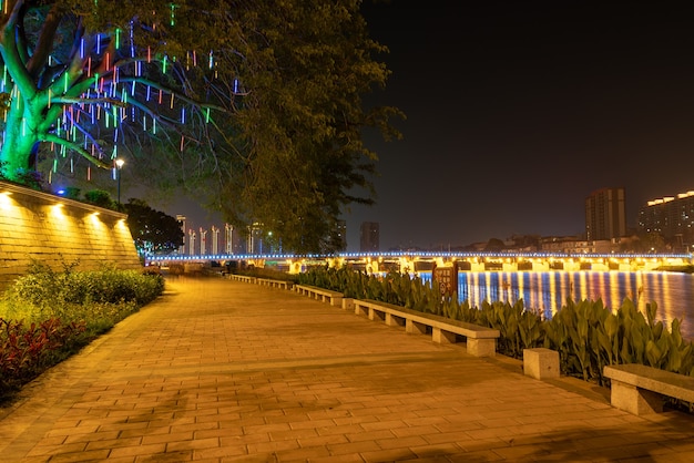 Dans la ville la nuit, des lumières colorées se reflètent dans l'eau de la rivière