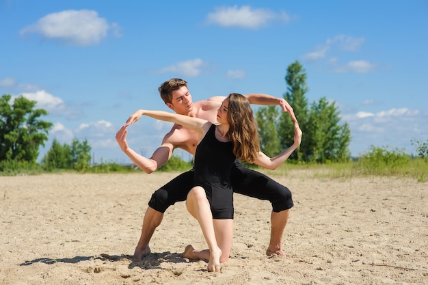 Danse contemporaine Homme et femme en danse passionnée posent sur la plage