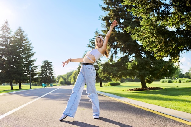 Danse jeune adolescente sur route dans le parc