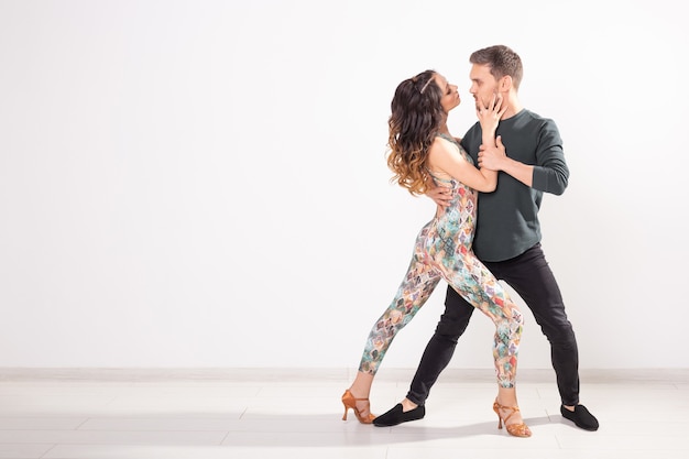 Danse sociale, bachata, kizomba, tango, salsa, concept de personnes - Jeune couple dansant sur fond blanc avec espace de copie