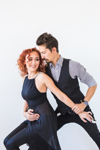 Danse sociale, bachata, kizomba, tango, salsa, concept de personnes. Jeune couple, danse, blanc