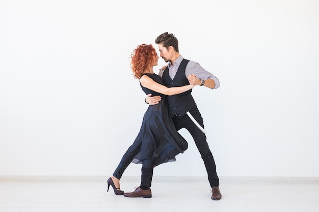 Danse sociale, kizomba, tango, salsa, concept de personnes - beau couple dansant la bachata sur un mur blanc avec espace copie